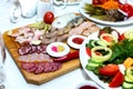 Cold meats on wooden plate on banquet table Royalty Free Stock Photo