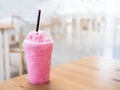 Cold milk smoothie in a plastic cup on a wooden table and has sunlight a beautiful background. Royalty Free Stock Photo