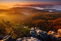 Cold misty foggy morning with sunrise in a fall valley of Bohemian Switzerland park. Hills with fog, landscape of Czech Republic,