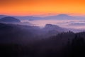 Cold misty foggy morning with twilight sunrise in a fall valley of Bohemian Switzerland park. Hills with fog, landscape of Czech Royalty Free Stock Photo