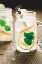 Cold Mojito Cocktail with Ice, Lemon and Mint Leaves in Mason Jar on Rustic Dark Wooden Background as Summer Concept Royalty Free Stock Photo