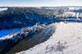 Cold morning over river starts on a bright sunny day, winter landscape. Nature in snow, aerial view