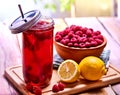 Cold non alcoholic cocktail with lemon half and raspberries bowl.