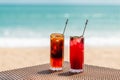 Cold Orange and Raspberry Cocktails on Table on Beach, Sunny Sea on Background Royalty Free Stock Photo