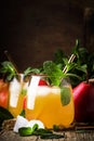 Cold pear juice, iced summer non-alcoholic cocktail with mint, old wooden table background, selective focus