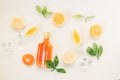 Cold refreshing alcohol drink bottle with two glasses , orange and lemon slices decoration on a white background .Top view, flat l