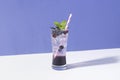 Cold and refreshing blueberry punch cocktail with mint on purple background. summer drink