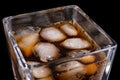 A cold refreshing drink with ice in a glass. Ice cubes and a sweet cold drink in a glass dish Royalty Free Stock Photo