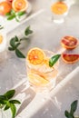 Cold refreshing drink with tonic, blood Sicilian oranges and ice, grey concrete background. Cocktail with tonic and oranges.