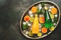 Cold refreshing drinks in bottles with ice and slices of citrus. Tarragon lemonade and orange juice. Top view, flat lay, copy Royalty Free Stock Photo