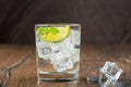 Cold, refreshing in the heat, sparkling water in a glass with ice cubes, lime wedge and mint leaves. Royalty Free Stock Photo