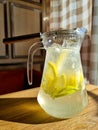 Cold refreshing limonade, mojito or gin tonic in glass, with fresh mint and ice cubes, lime and lemon on wooden table Royalty Free Stock Photo