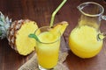 Cold refreshing pineapple mocktail drink in glass and pitcher