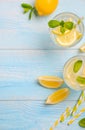 Cold refreshing summer drink with lemon and mint on light blue wooden background. Royalty Free Stock Photo