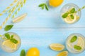 Cold refreshing summer drink with lemon and mint on light blue wooden background. Royalty Free Stock Photo