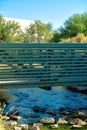 Cold river flowing under metal footbridge in a natural area used by joggers or hiker to cross over stream or lake Royalty Free Stock Photo