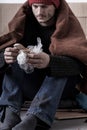 Cold and sad homeless man is eating a bread Royalty Free Stock Photo