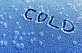 Cold season concept. Text cold written on the frost snowy surface. Royalty Free Stock Photo