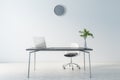 Cold shadows interior design of home office waork place with modern laptop on dark marble table, grey wall clock on light