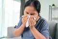 Cold sick woman got nose allergy cough or sneeze with tissue paper sitting on the sofa. Healthcare and medical concept Royalty Free Stock Photo