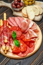 Cold smoked meat plate with pork chops, prosciutto, salami and bread sticks Royalty Free Stock Photo