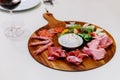 Cold smoked meat plate with prosciutto, salami, bacon, pork chops, cheese and olives on wooden plate with red wine . Royalty Free Stock Photo