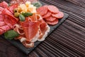 Cold smoked meat plate on a rustic wooden background