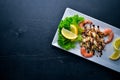 Cold snacks. Seafood, shrimp, mussels, squid, octopus. On a wooden background. Royalty Free Stock Photo