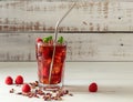 Cold sparkling hibiscus or karkade tea with lemon, mint, and ice in glass on a wooden table. Royalty Free Stock Photo