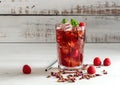 Cold sparkling hibiscus or karkade tea with lemon, mint, and ice in glass on a wooden table. Royalty Free Stock Photo