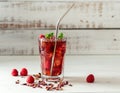 Cold sparkling hibiscus or karkade tea with lemon, mint, and ice in glass on a wooden table. Royalty Free Stock Photo