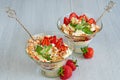 Cold summer dessert with sliced strawberries, whipped cream in the glass bowls on the gray kitchen background. Decorated with mint Royalty Free Stock Photo