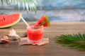 Cold summer fruit drink, fresh watermelon mocktail on wooden table with seashells Royalty Free Stock Photo
