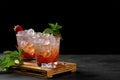 Cold summer strawberry iced cocktail mojito, margarita, daiquiri in two glasses with mint leaves on dark background Royalty Free Stock Photo