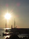 A cold sunrise on a still morning reflects the yachts between the lighthouse and the rocks of Mevagissey harbour