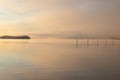 A cold sunrise in the winter over a lake with veils of mist creating a fairy tale environment with a minimalist view and soft colo Royalty Free Stock Photo