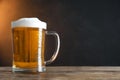 Cold tasty beer on wooden table against dark background. Space for text Royalty Free Stock Photo