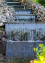 Decorative artificial waterfall in summer park. Royalty Free Stock Photo