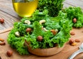 Cold vegetable leaf salad with mixed nuts on a wooden board. Royalty Free Stock Photo