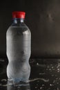 Cold water in a bottle on a black background. A bottle of water stands on a black background. Cool summer drinks Royalty Free Stock Photo