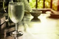 Cold water and dew drop in wine glass on the table. beauty golden light reflection from window background with copy space. no peop Royalty Free Stock Photo