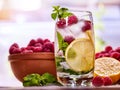 Cold water with lemon and mint leaf. Raspberries lemonade. Royalty Free Stock Photo