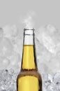 Cold wet open beer bottle with smoke on ice cubes background Royalty Free Stock Photo