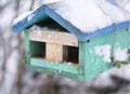 Cold winter Blue roof and green wall is birdhouse covered in snow