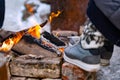 In the cold winter day a person heats feet to the fire. Royalty Free Stock Photo