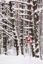 Cold winter landscape. Winding road sign in dense forest among trees covered in snow Royalty Free Stock Photo