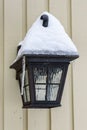 Cold winter, snow and ice covered black light fixture on an exterior wall Royalty Free Stock Photo