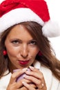 Cold young woman in a Santa hat sipping coffee tea Royalty Free Stock Photo