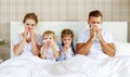 Colds and viral diseases. family with runny nose and fever in bed Royalty Free Stock Photo