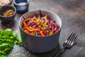 Coleslaw in a gray bowl on dark background. Red cabbage and carrot salad